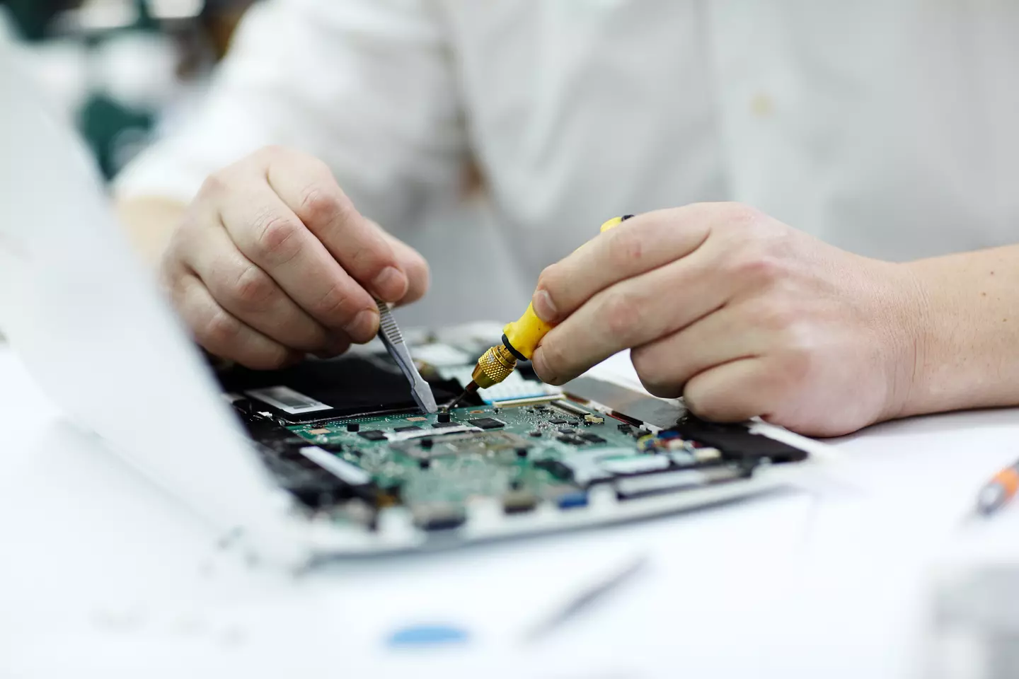Image of hands repairing an electronic board